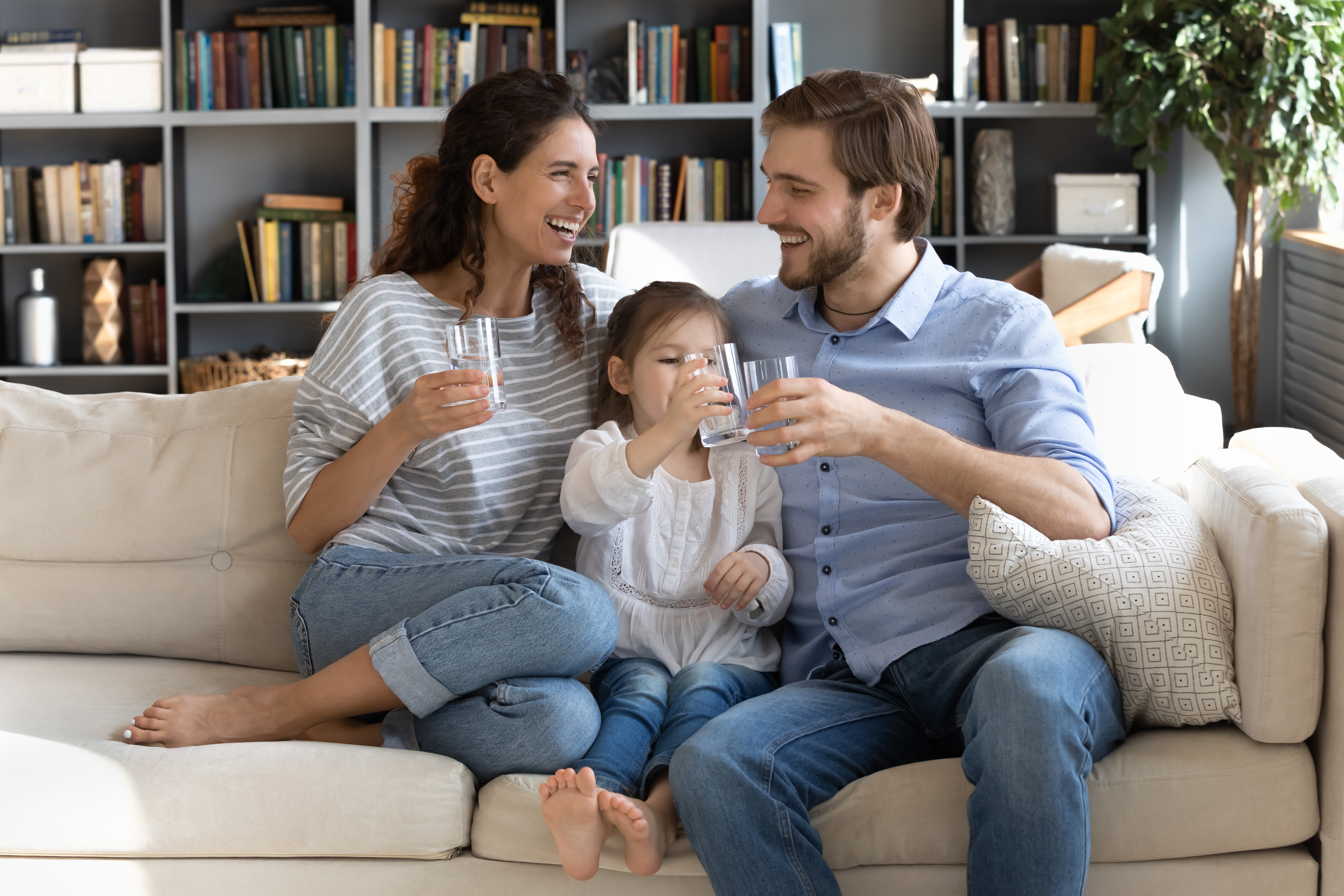 Happy family drinking clean filtered water at home